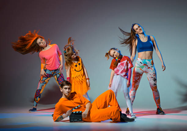 Group of man, woman and teens dancing hip hop choreography Group of man, woman and teens dancing hip hop choreography and posing at studio on gray dance troupe stock pictures, royalty-free photos & images