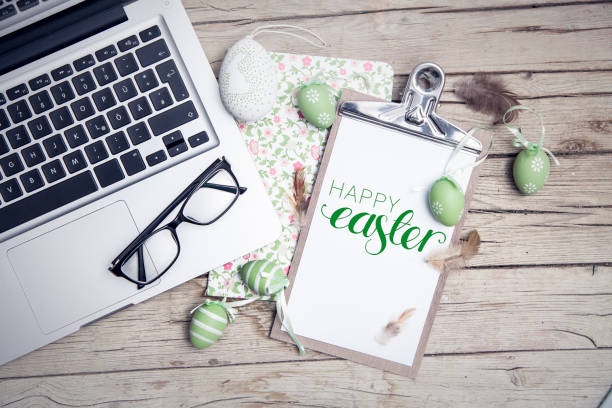 easter background with eastereggs and butterflies on wooden table an notebook
