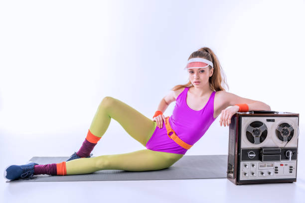 istock sporty woman lying on training mat near retro record player on white 656555036