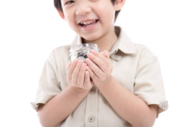 istock Cute Asian child saving money in glass bottle 656555920