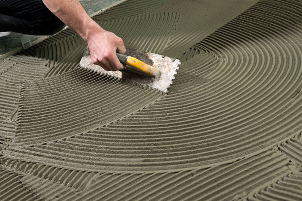 construction worker applying ceramic glue - tile adhesive imagens e fotografias de stock