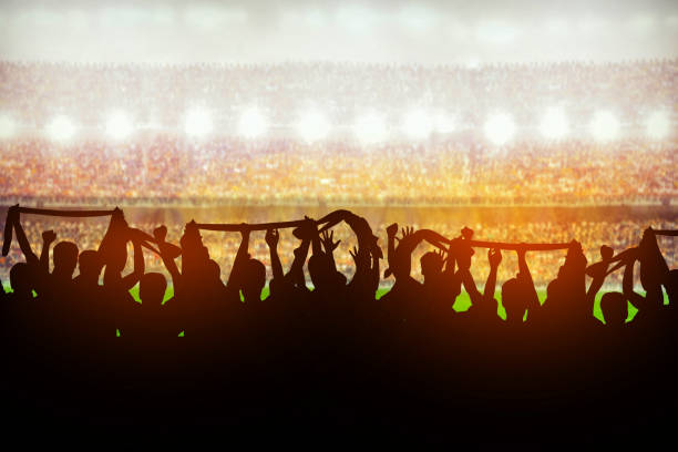 Silhouettes of soccer or rugby supporters in the stadium during match Silhouettes of soccer or rugby supporters in the stadium during match sports event stock pictures, royalty-free photos & images