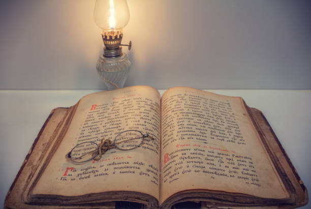 istock Opened vintage book with old eyeglasses and kerosene lantern 656571218