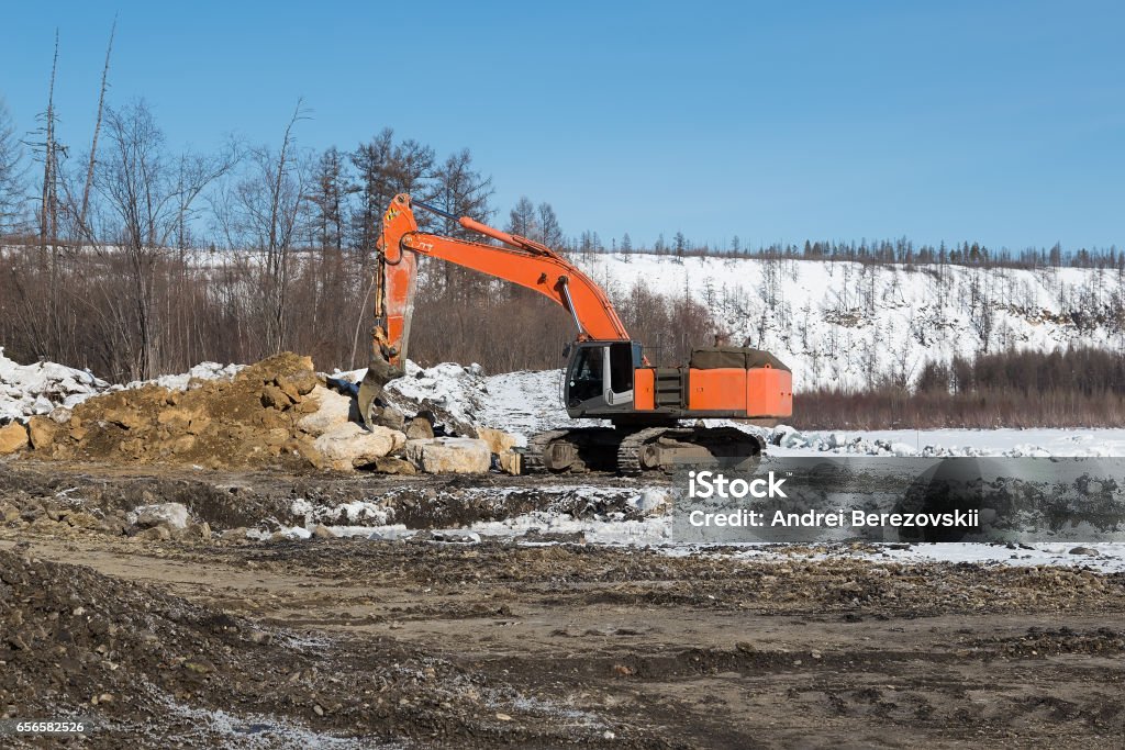 Excavator with fang-ripper orange digger with fang ripper in winter Activity Stock Photo