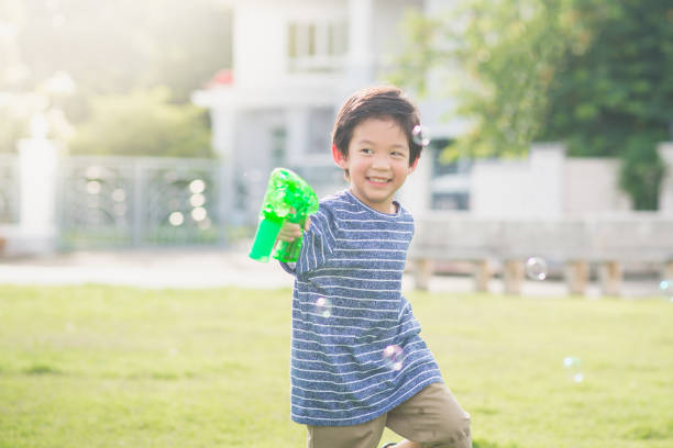 istock Asian child Shooting Bubbles from Bubble Gun 656587790