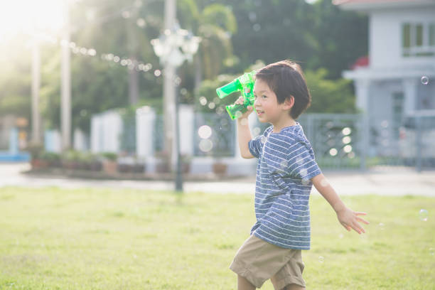 istock Asian child Shooting Bubbles from Bubble Gun 656587796