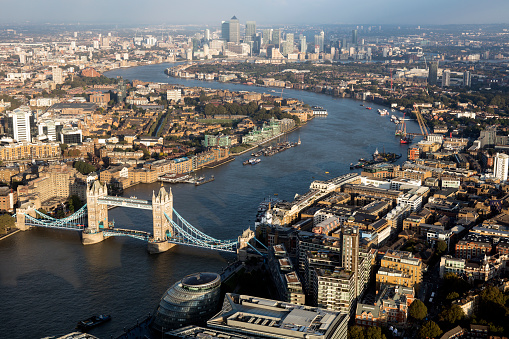Tower Bridge, Thames River and London cityscape with Canary Wharf financial district in the background, aerial view
