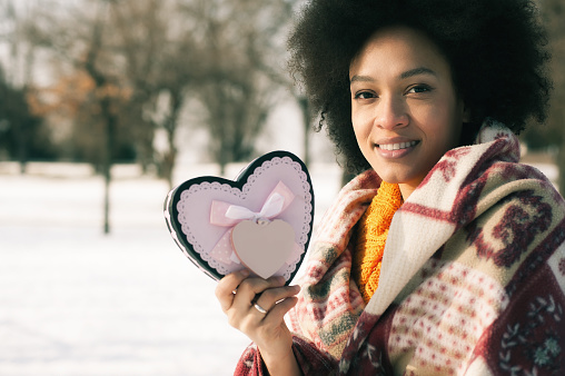 Happy young smiling woman with big heart in winter day. Valentines Day