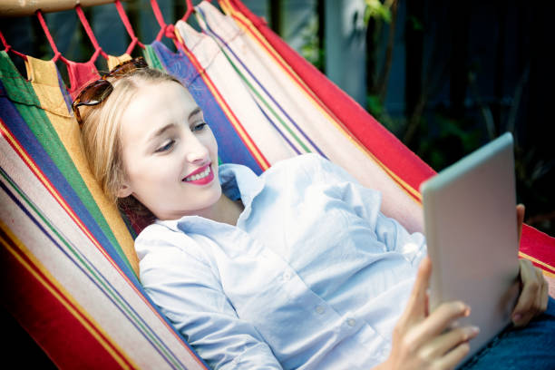 istock Young Woman Relaxing  On Hammock With Digital Tablet 656622018