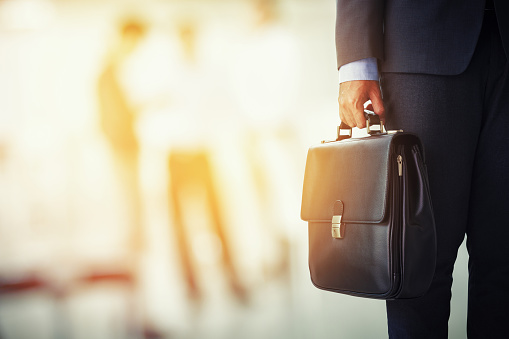 businessman holding his briefcase in office