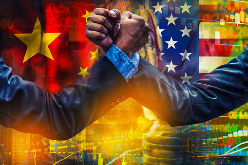 hombre de negocios que compiten en pulseada sobre fondo de bandera de Estados Unidos y china photo