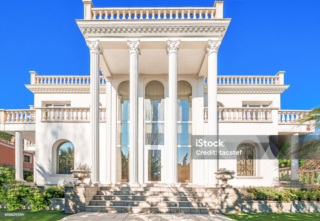 The facade of a luxurious residence with column The facade of a luxurious residence with columns in the Corinthian style, with large windows. Luxury house in a classic style. Beautiful exterior and front entrance. Mansion Stock Photo