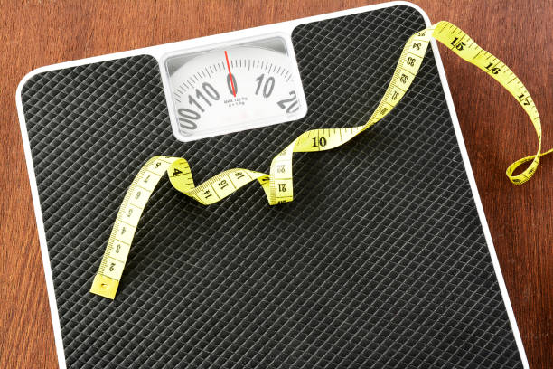 istock Measuring tape on black weight scale. 656631038