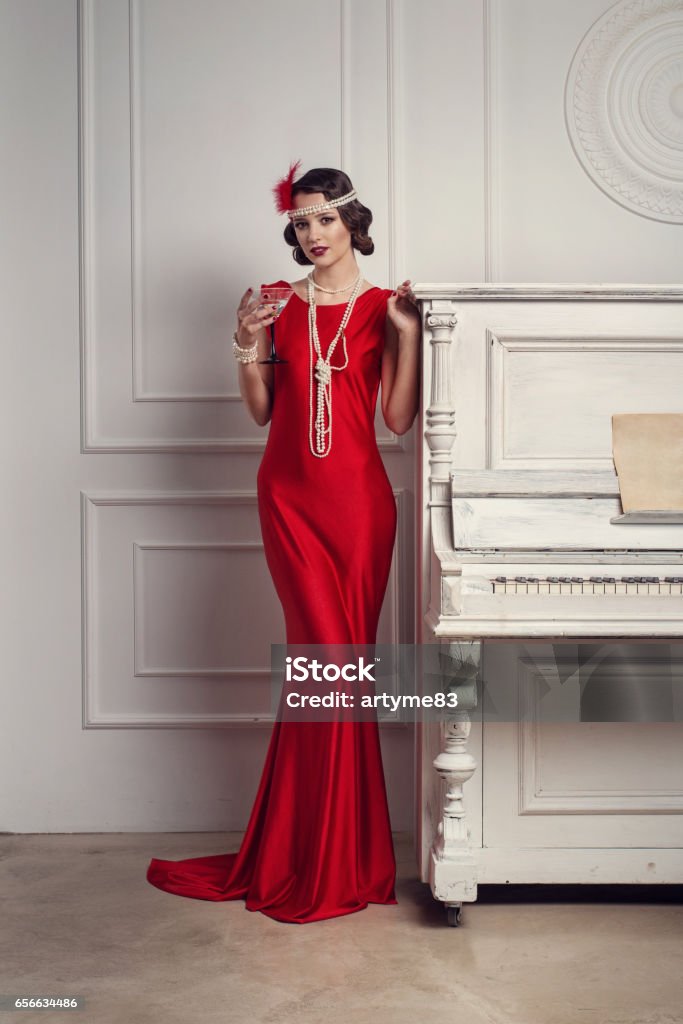 Young Beautiful Girl In Red Dress Style Of The 20s Or 30s With Glass Of  Martini Near The Piano Vintage Style Beautiful Woman Old Fashioned Makeup  And Retro Finger Wave Hairstyle Stock