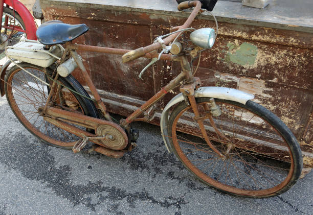 Old rusty bicycle moped with motor engine  and the gasoline tank