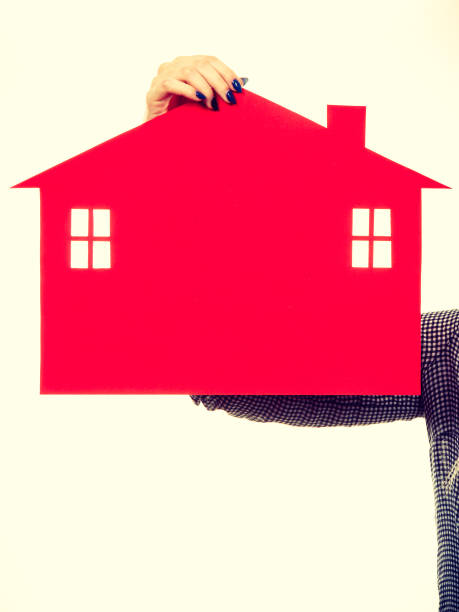istock Female hand holding red paper house symbol 656642092