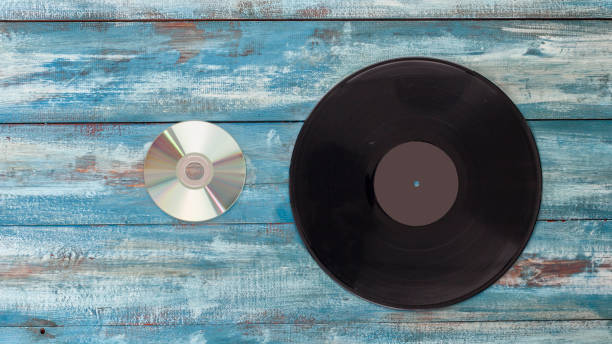 vinyl records and cd disk  on an old vintage blue color background - dvd obsolete cd cd rom imagens e fotografias de stock