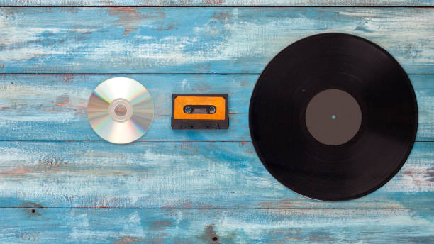 disques vinyles, disque cd et bande audio sur un vieux fond de couleur bleu vintage - dvd obsolete cd cd rom photos et images de collection