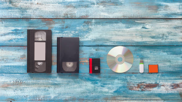 video cassettes, audio cassettes, and usb, flash drive on the old vintage blue background - dvd obsolete cd cd rom imagens e fotografias de stock