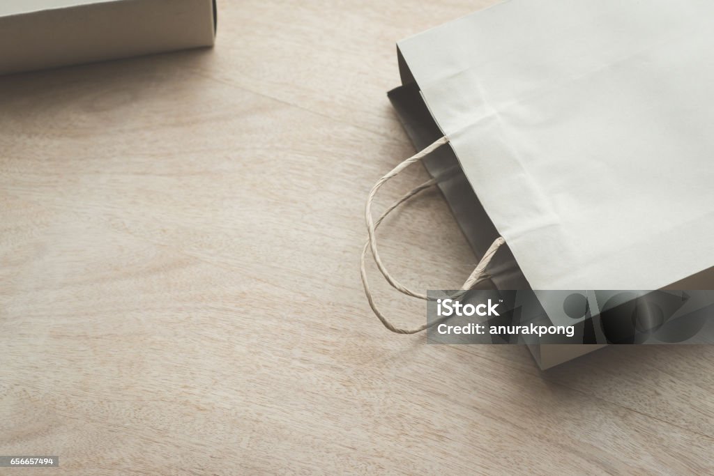 Paper bag on a wooden background Empty Paper bag on a wooden under sunlight Bag Stock Photo