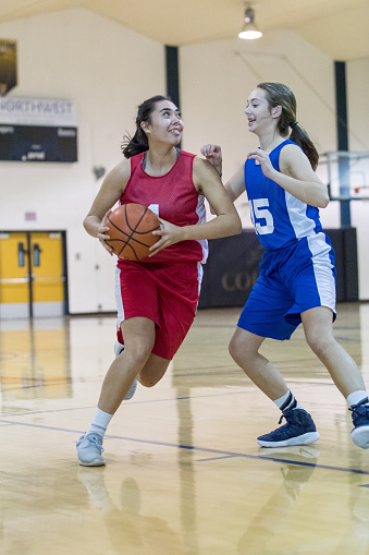 Player dribbles at the top of the key as she prepares to drive to basket