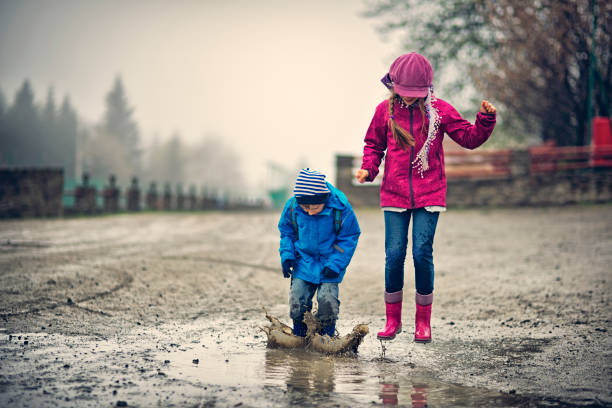 istock Brother and sister hikers playing in a early spring puddle 656662356