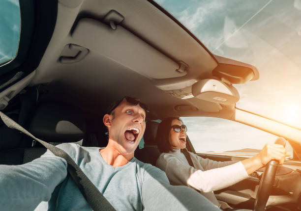 istock Screaming couple riding in car wide angle view 656664922