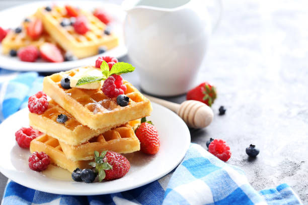 istock Homemade waffles with berries in plate on grey table 656664962