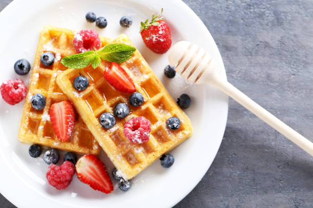 istock Homemade waffles with berries in plate on grey table 656665298