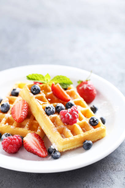 istock Homemade waffles with berries in plate on grey table 656665352