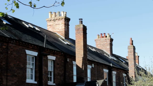 Chimneys, windows, slate tiled roof tops of traditional Victorian houses