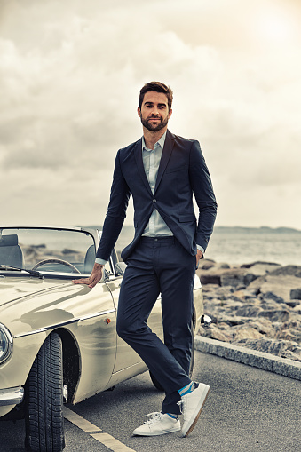 Cool guy with sports car on road, portrait