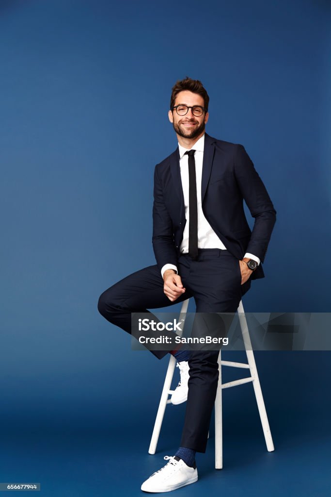 Business dude on stool Businessman on stool in studio, portrait Men Stock Photo
