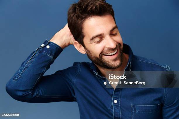 Laughing In Blue Stock Photo - Download Image Now - Hand In Hair, Fashion Model, Only Men