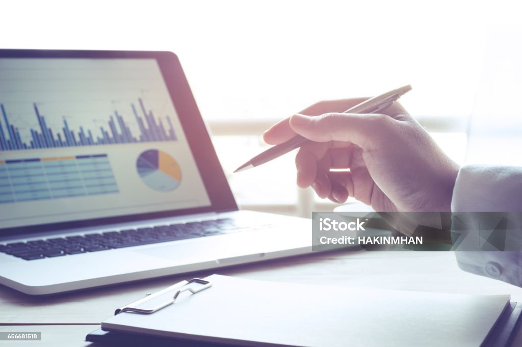 Businessman with notebook and modern laptop with graph Businessman working with notebook and modern laptop with business graph chart.business marketing,success and ideas concept Commercial Activity Stock Photo