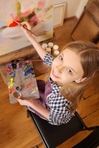 istock Smiling girl practicing painting in the art school 656692702
