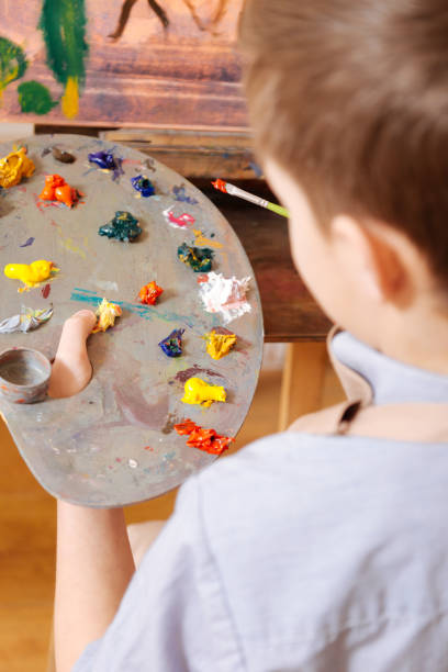 istock Concentrated child mixing colors in the art studio 656693438