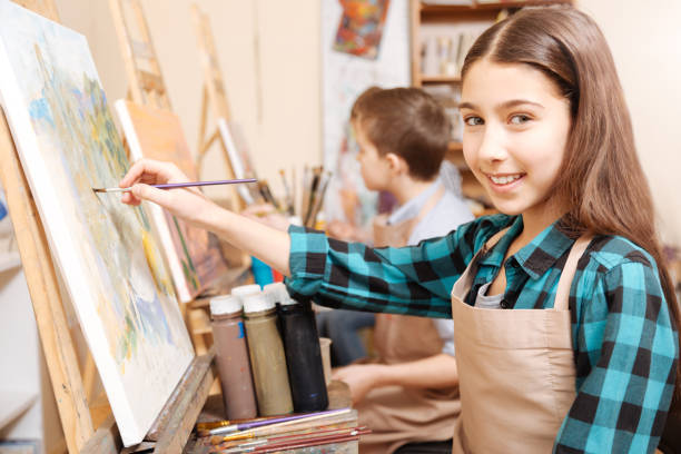 istock Charming young girl enjoying art lesson at school 656698270