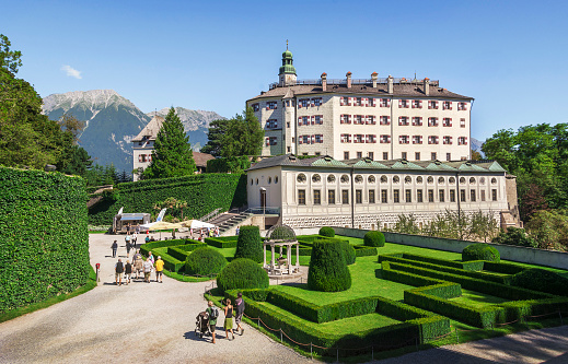 INNSBRUCK, AUSTRIA - AUGUST 28, 2016. Ambras Castle and the green garden in Innsbruck,  one of the most popular tourist attractions of the Tyrol, Austria. Ambras Castle, built in the 16th century,  is a famous cultural and historical place.