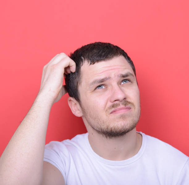 istock Portrait of man thinking against red background 656700654