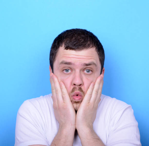 istock Portrait of man with dusgusted gesture against blue background 656700716