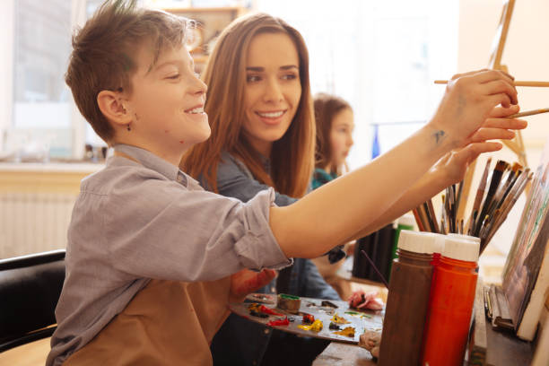istock Enthusiastic young teacher helping children in the art studio 656703564