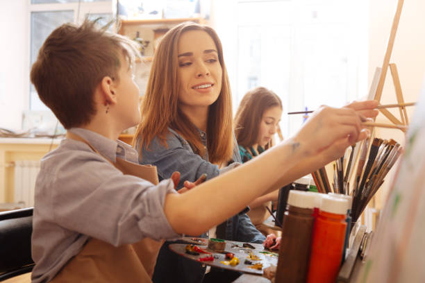 istock Charming young artist helping children in the art studio 656703700