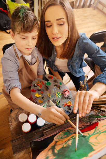 istock Helpful artist painting with child in the art studio 656703812