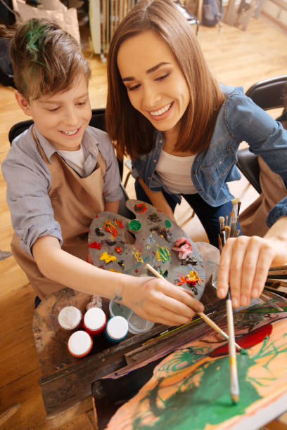 istock Positive painter teaching art child at school 656703920
