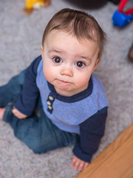 istock Baby Boy Sitting On Floor Looking Up 656704544