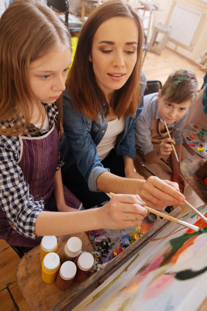 istock Concentrated artist teaching painting kids in the studio 656704620