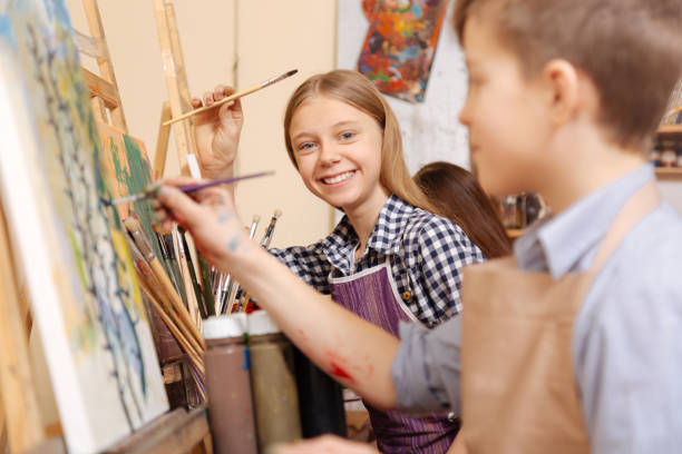 fröhliche kinder malen in der kunstschule - easel adult art creativity stock-fotos und bilder
