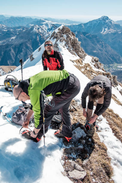istock Climbers on the mountain top fasten crampon 656704970