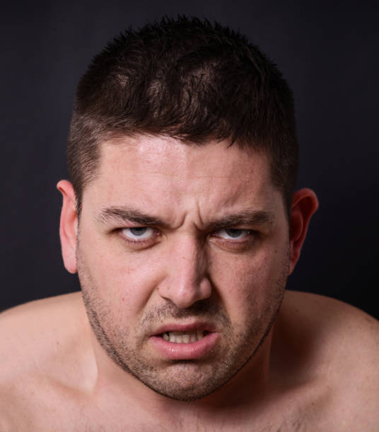istock Portrait of angry man against dark background 656711254